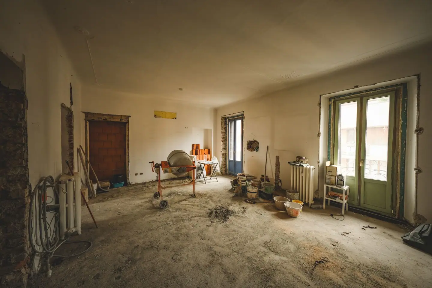 Altbauwohnung in der Sanierung mit Mischmaschine und freigelegten Wänden