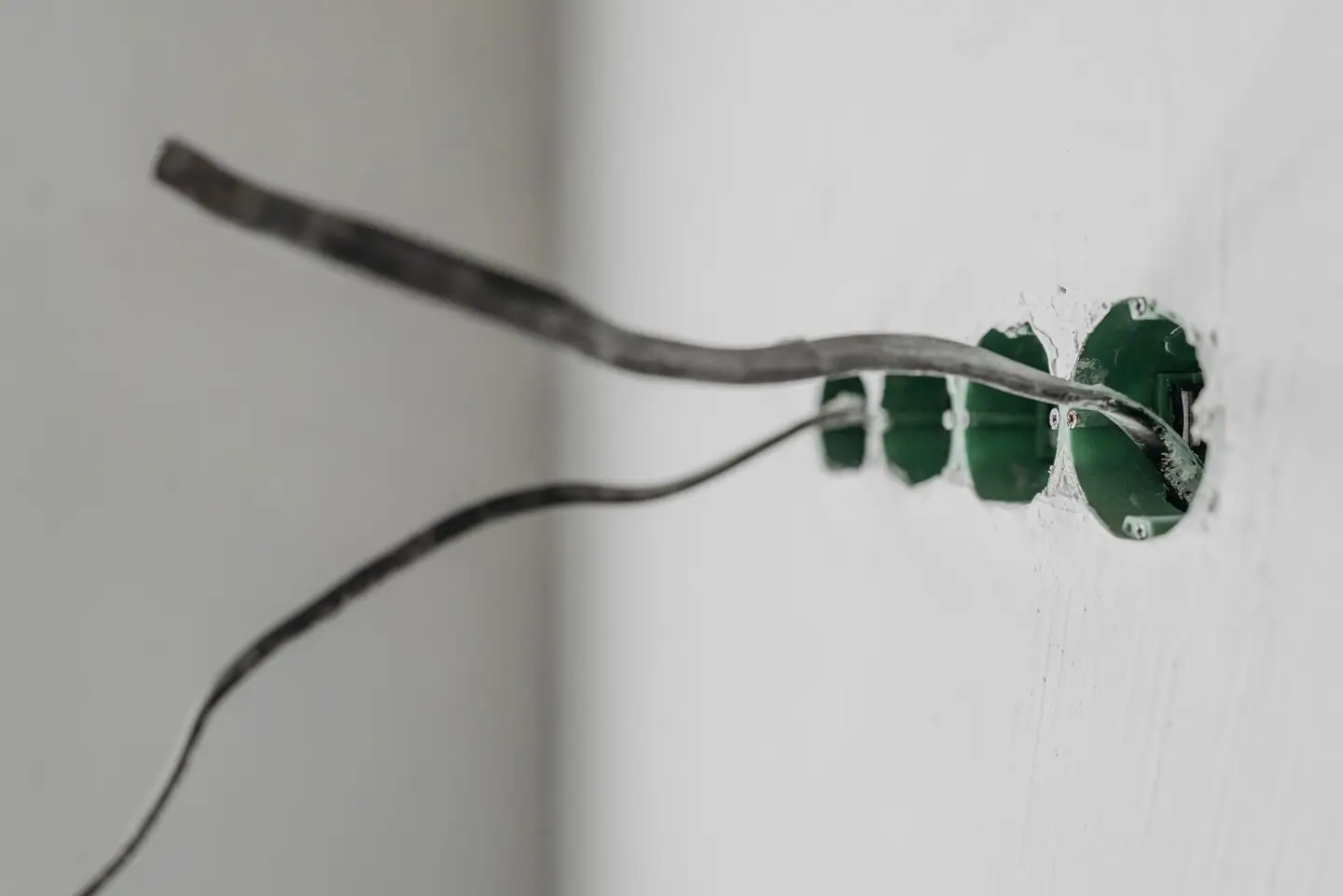 Unterputzdosen mit herausgeführten Leitungen in weißer Wand