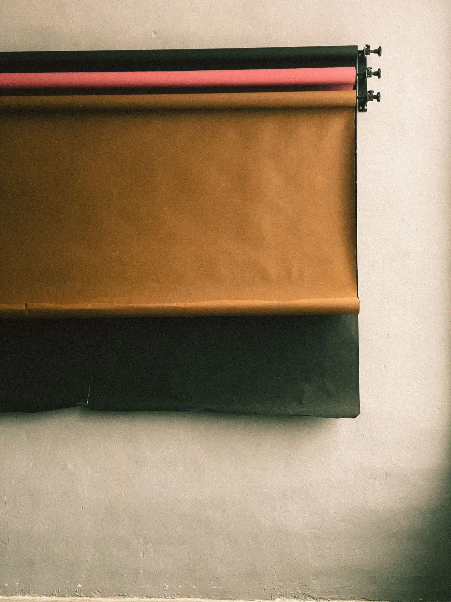 Hintergrundpapier in Braun, Rosa und Schwarz an der Atelierwand