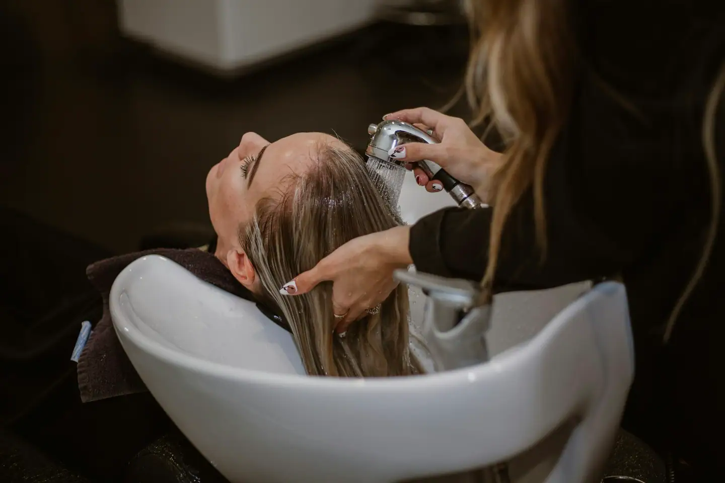 Haarwäsche am Waschbecken mit Handbrause
