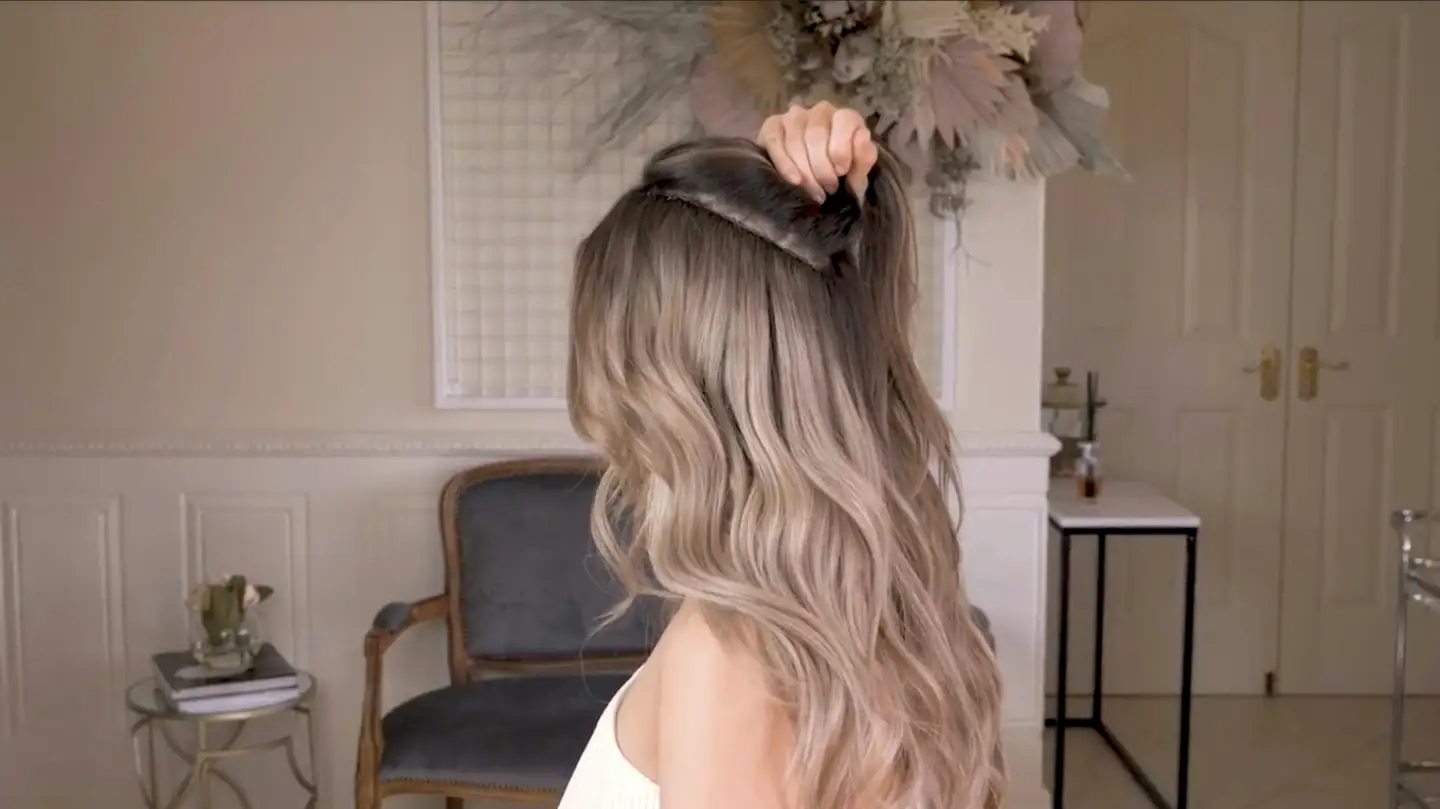 Lange, wellige Haare in Blondtönen, seitlich von hinten