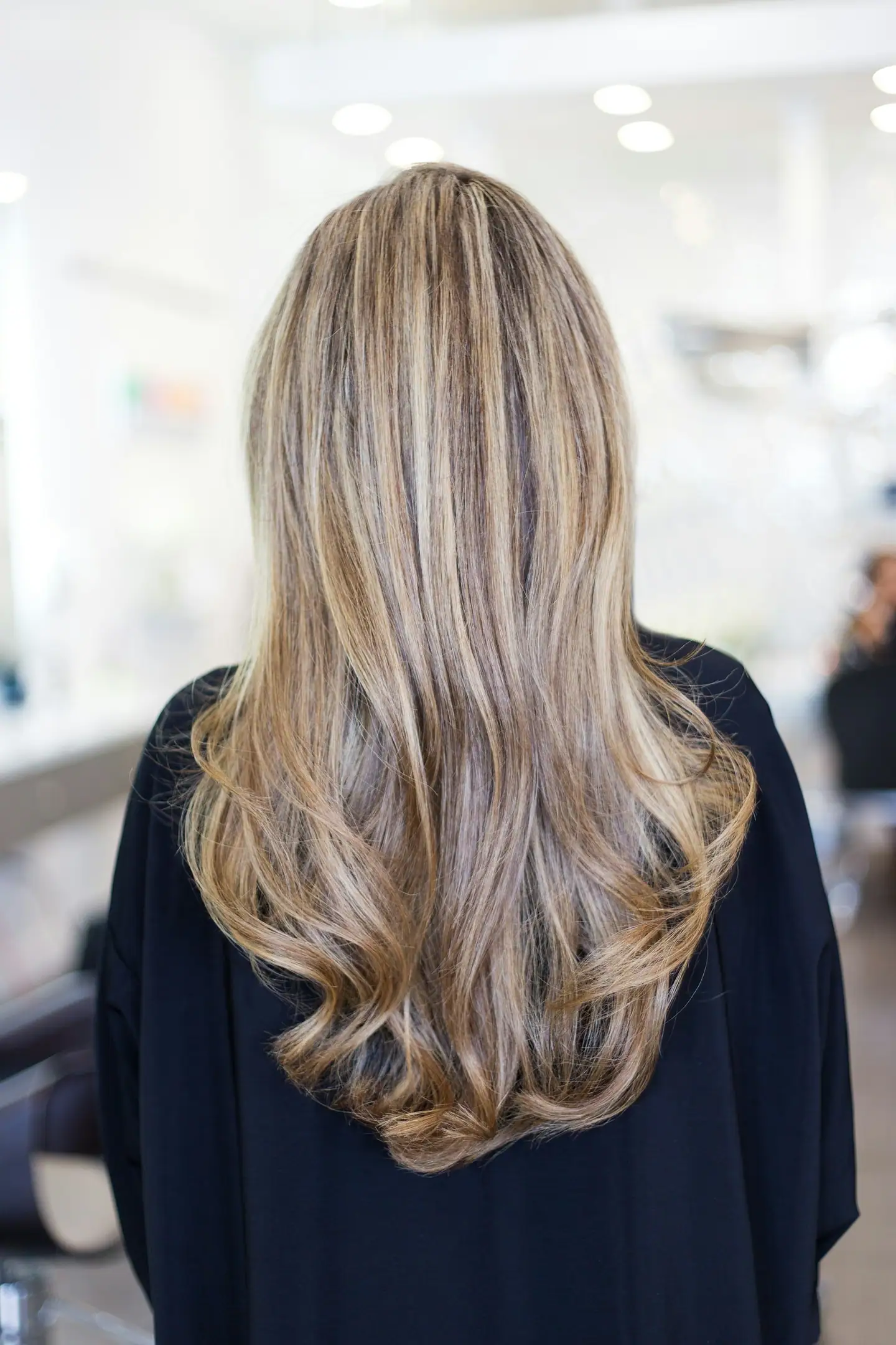 Lange Haare mit Strähnen und Wellen, von hinten im Salon