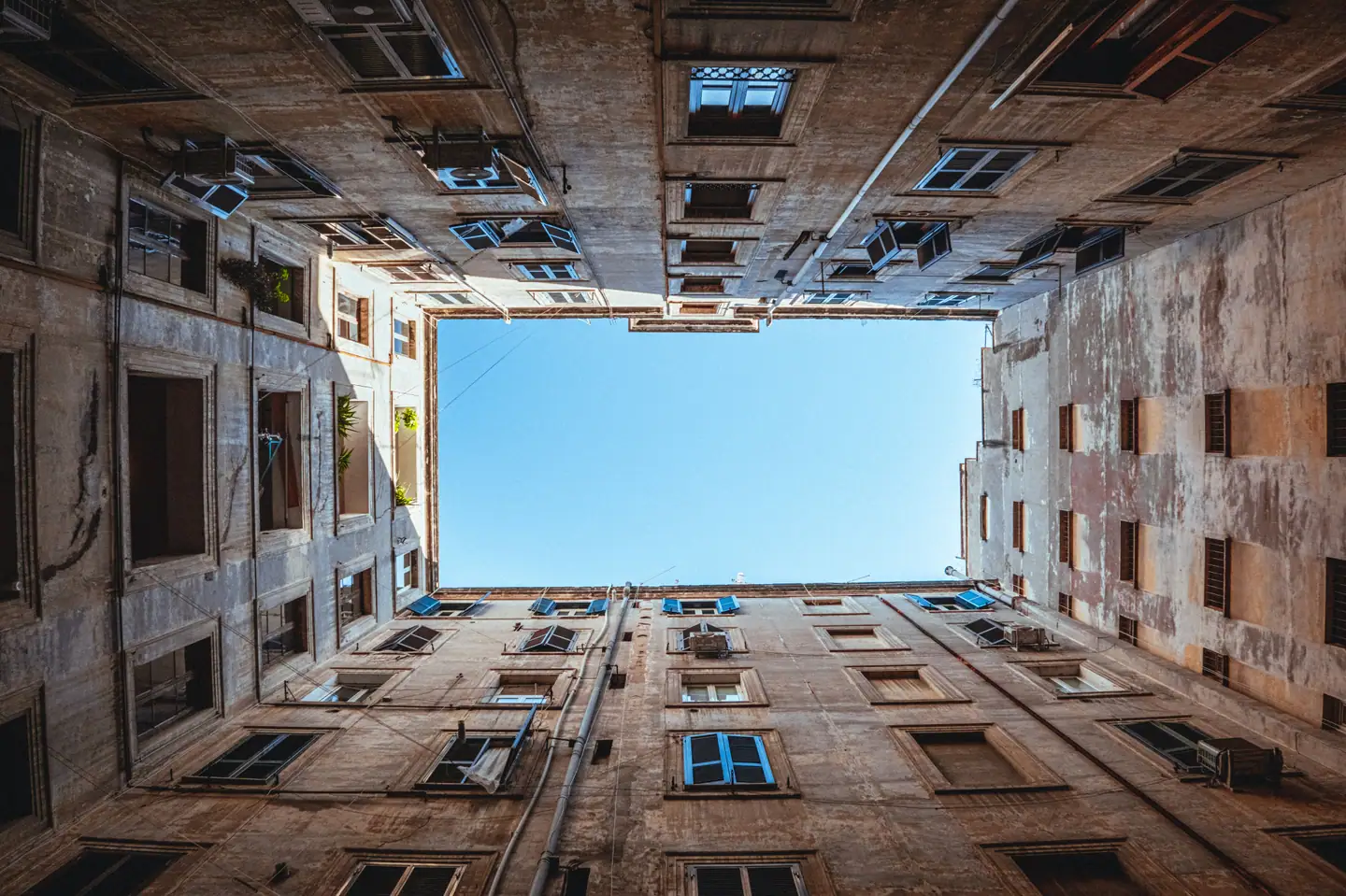 Blick aus einem Wiener Innenhof nach oben auf Fassaden und ein Stück Himmel