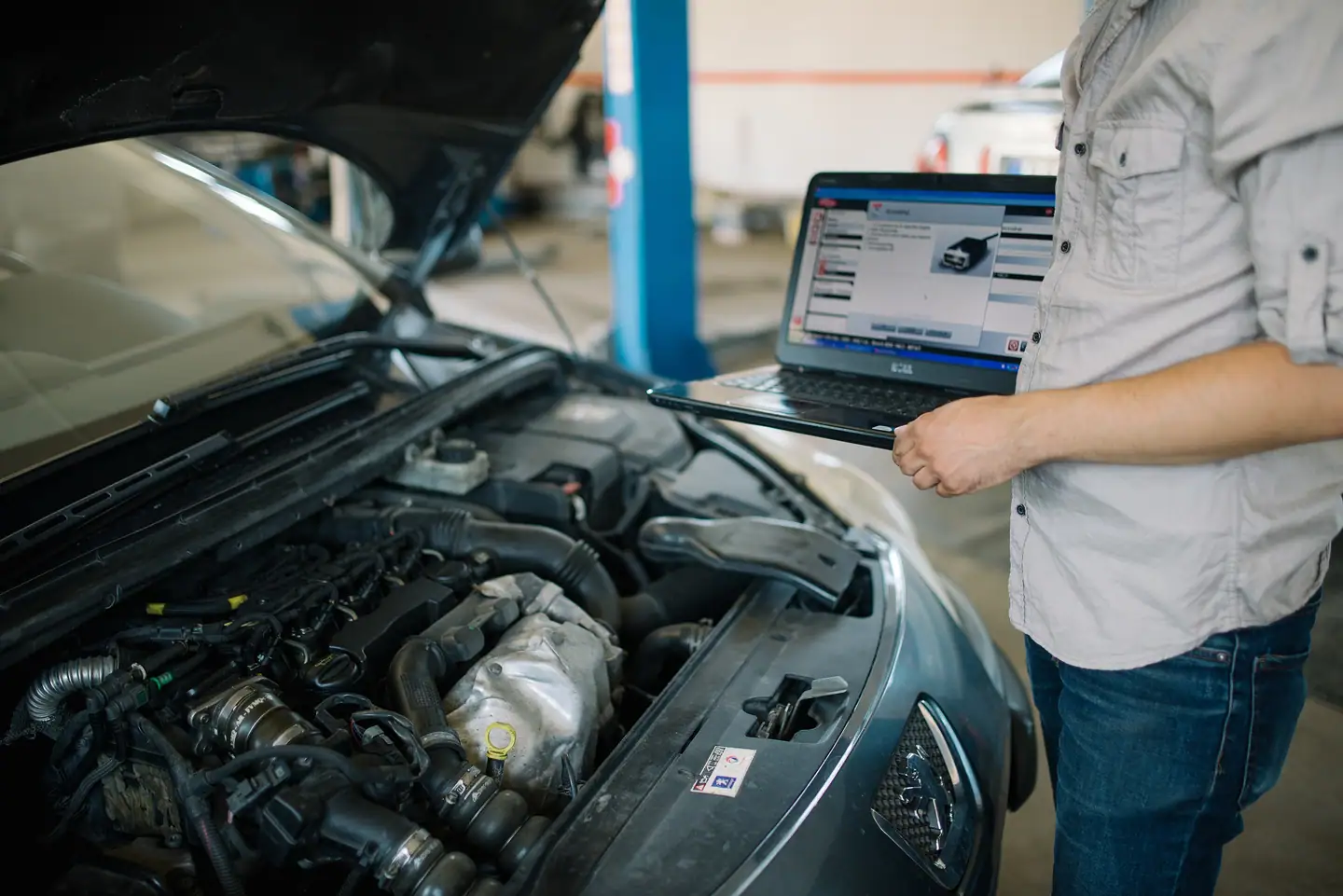 Fehlerdiagnose am offenen Motorraum mit Laptop