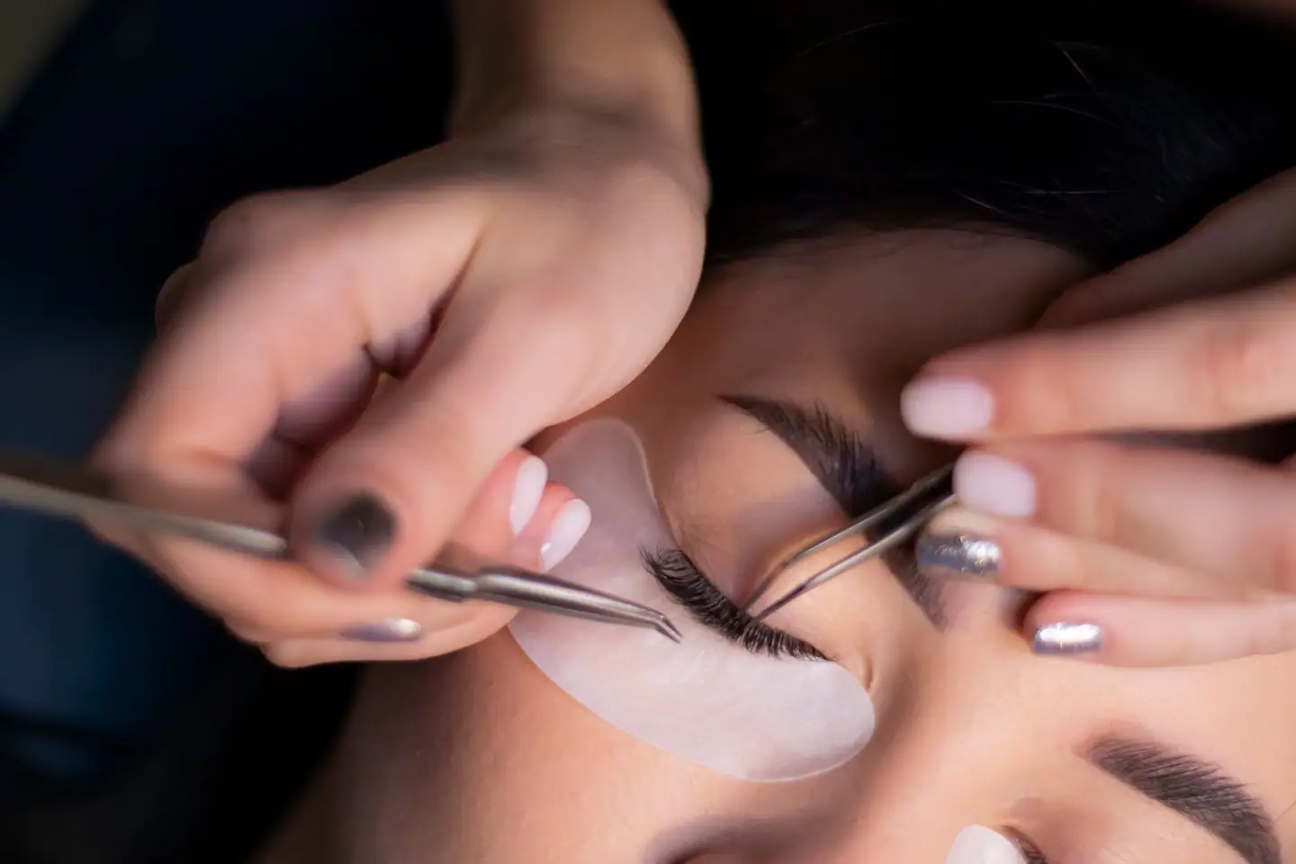 Wimpernverlängerung mit zwei Pinzetten, Augenpad unter dem Auge