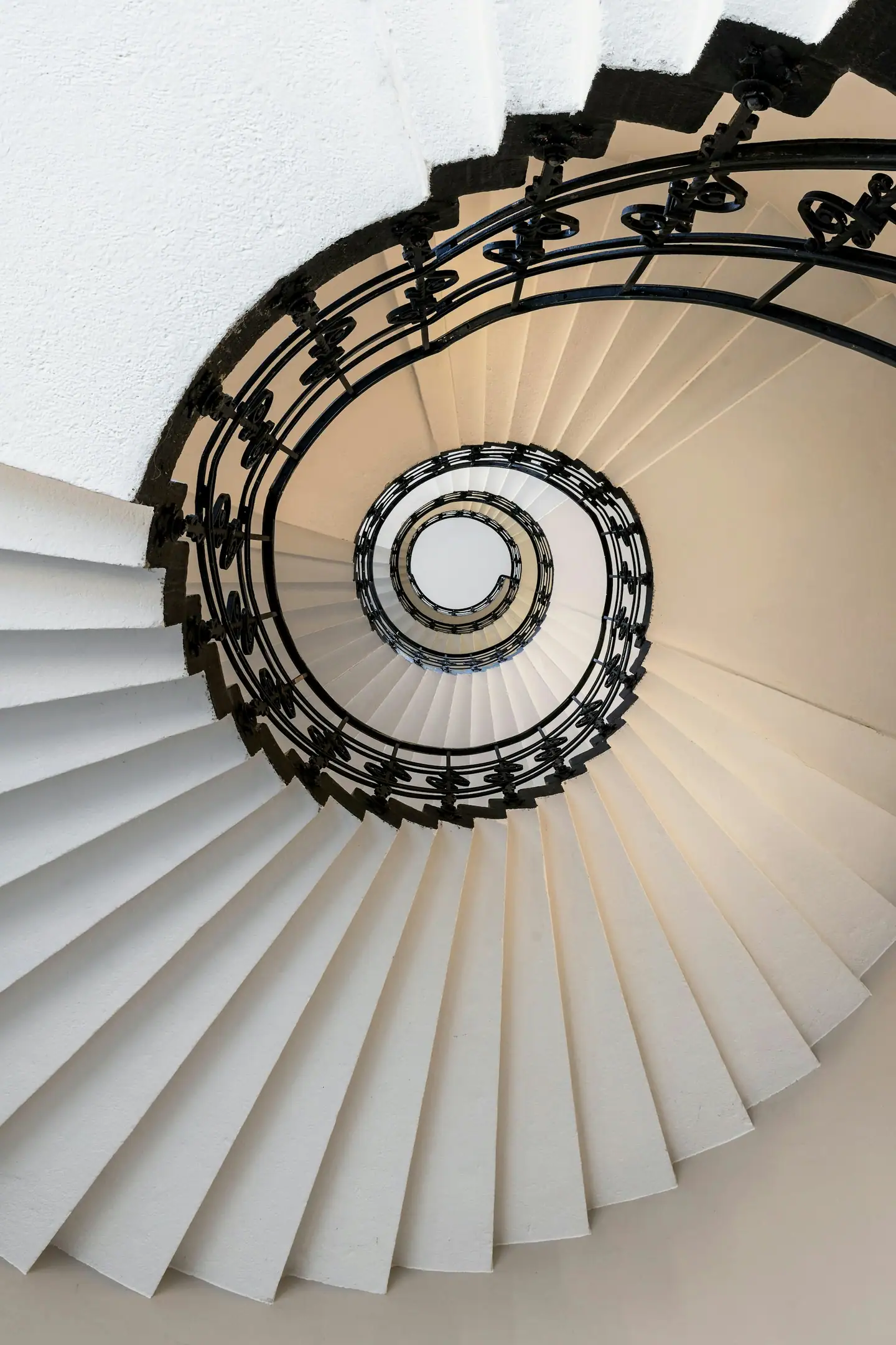 Gepflegte Wendeltreppe mit schmiedeeisernem Geländer von unten gesehen